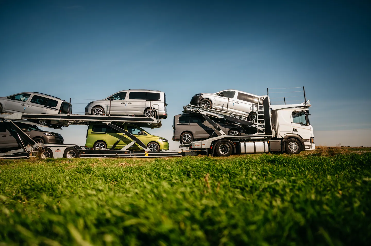 Widok z boku na vany przewożone autotransporterem Guess Polska