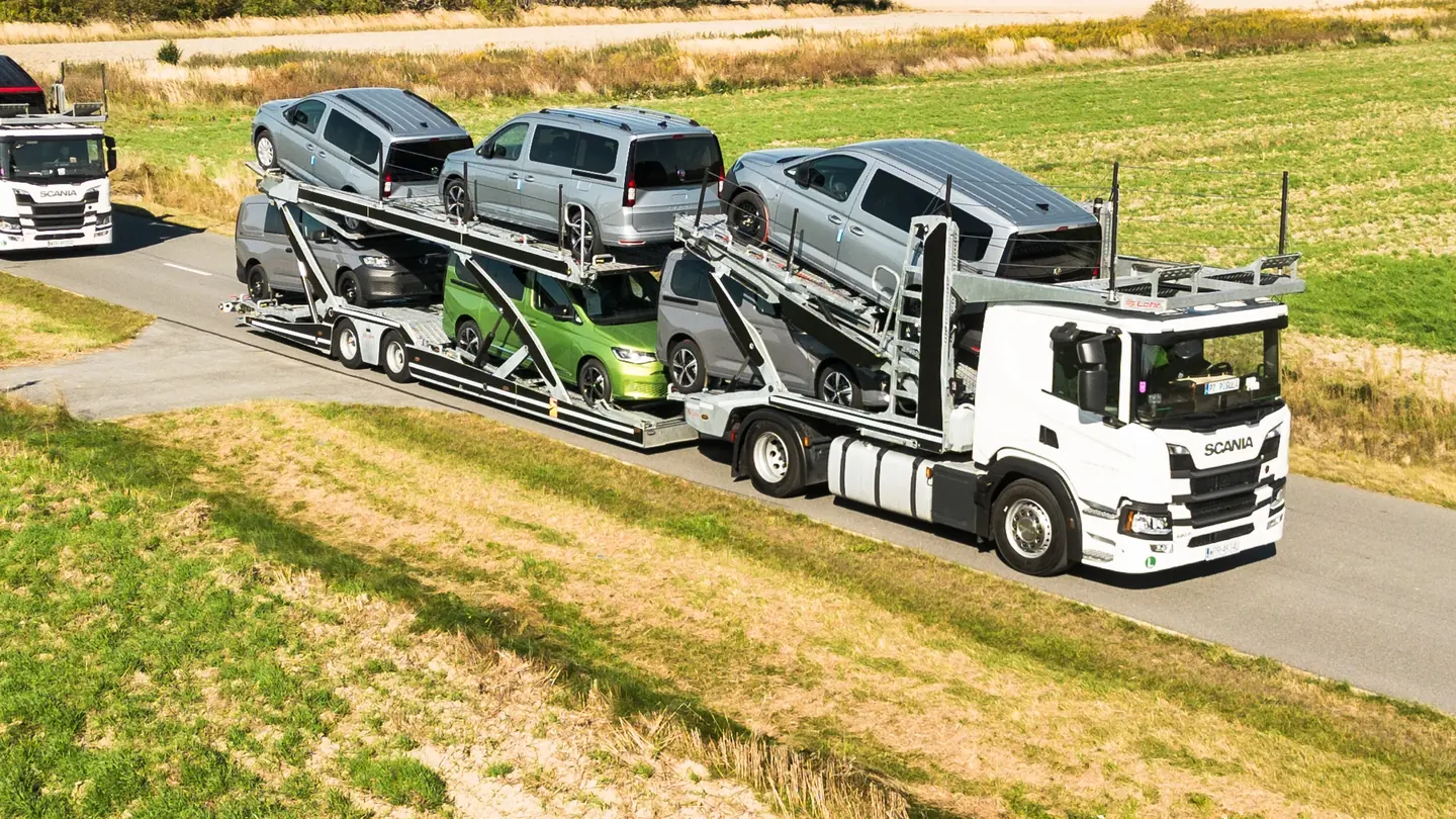 Załadowany autotransporter Scania Guess Polska na drodze przy polu, widok z góry i z boku.