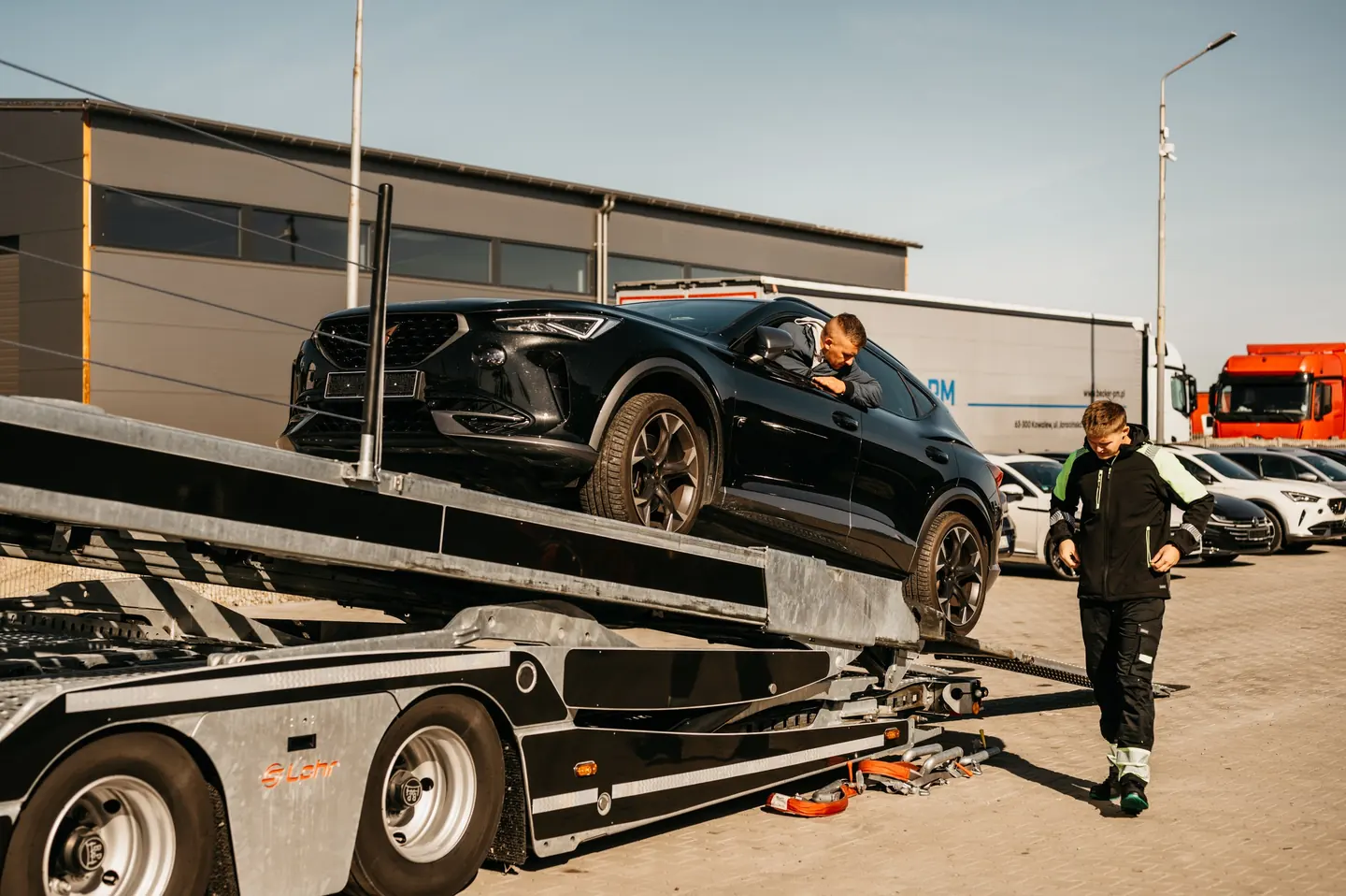 Pracownicy przy załadunku samochodu na autotransporter Guess Polska